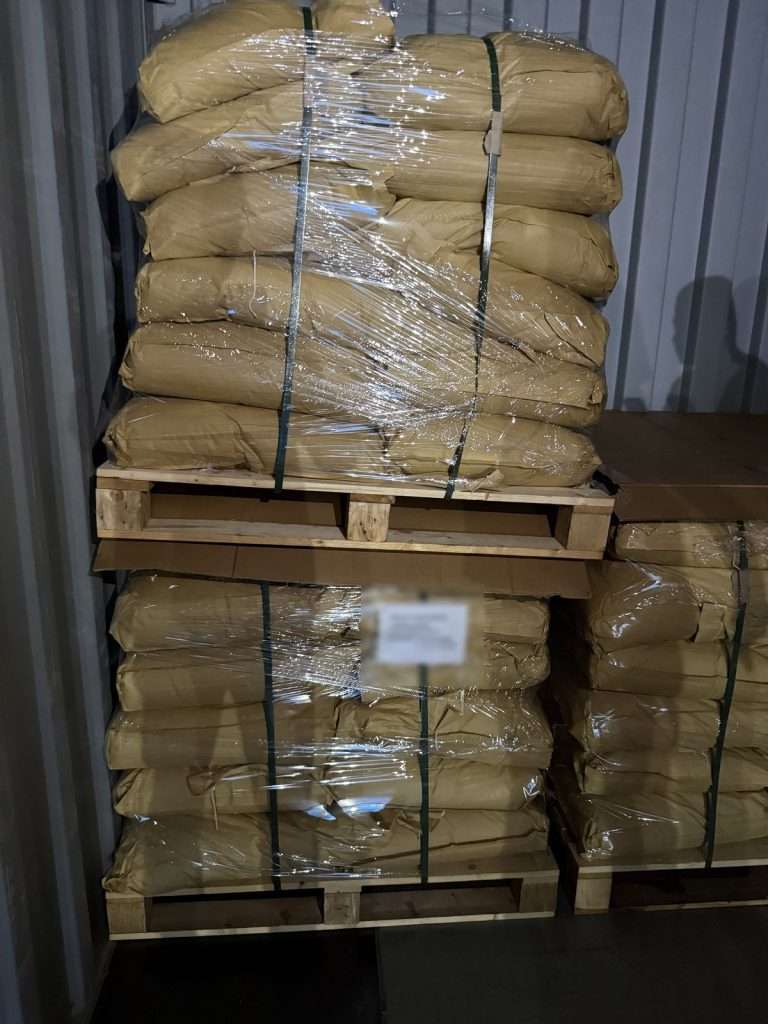 Strapped pallet of 25 kg lignosulfonate bags inside a container