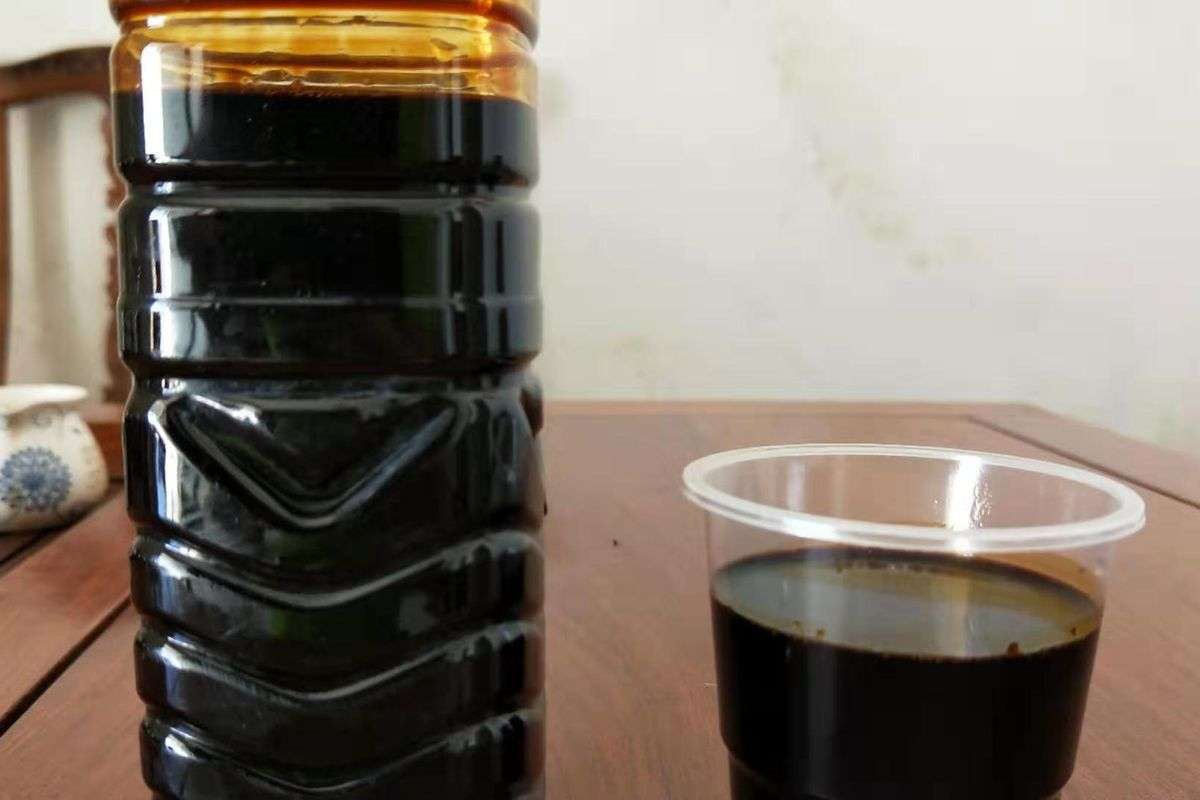 Liquid lignosulfonate sample in a bottle and cup