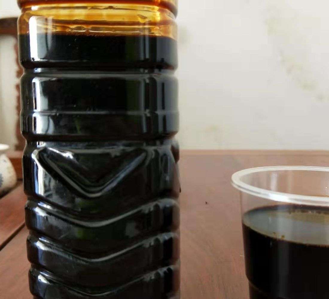 Sodium lignosulfonate liquid sample in a bottle and cup